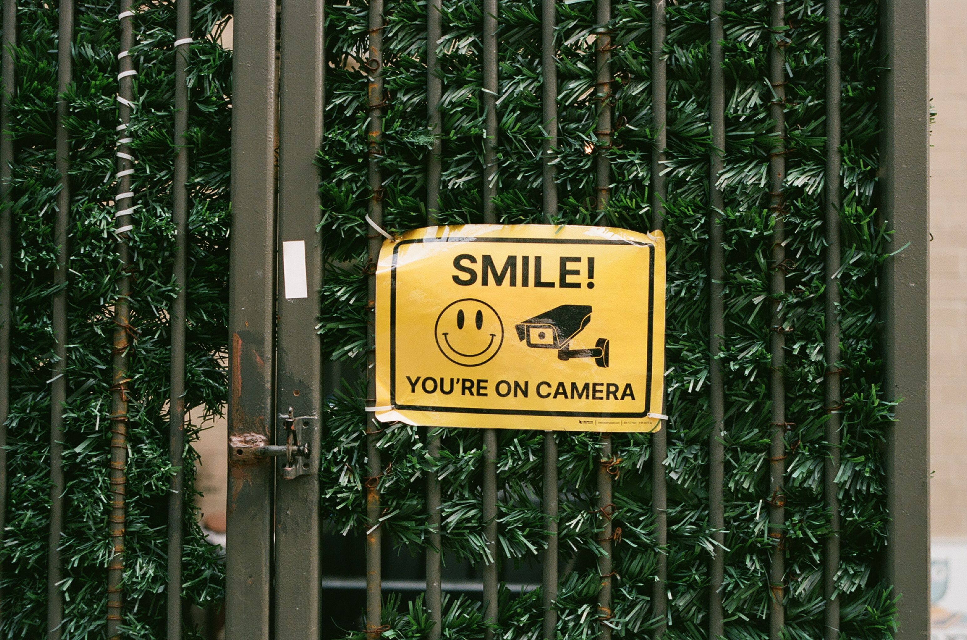 Yellow sign reading Smile, you're on camera