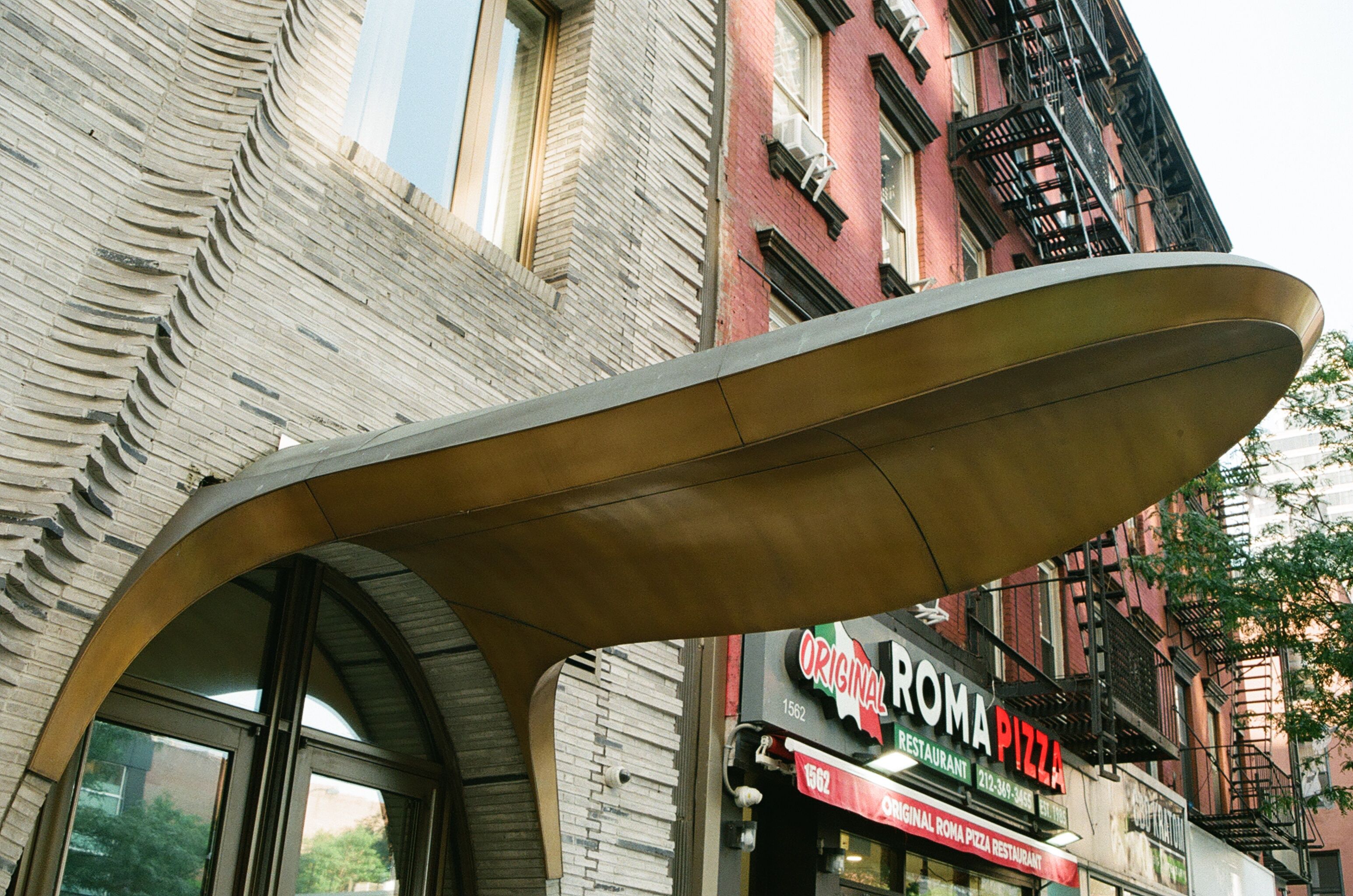 Curved metal canopy beneath city buildings