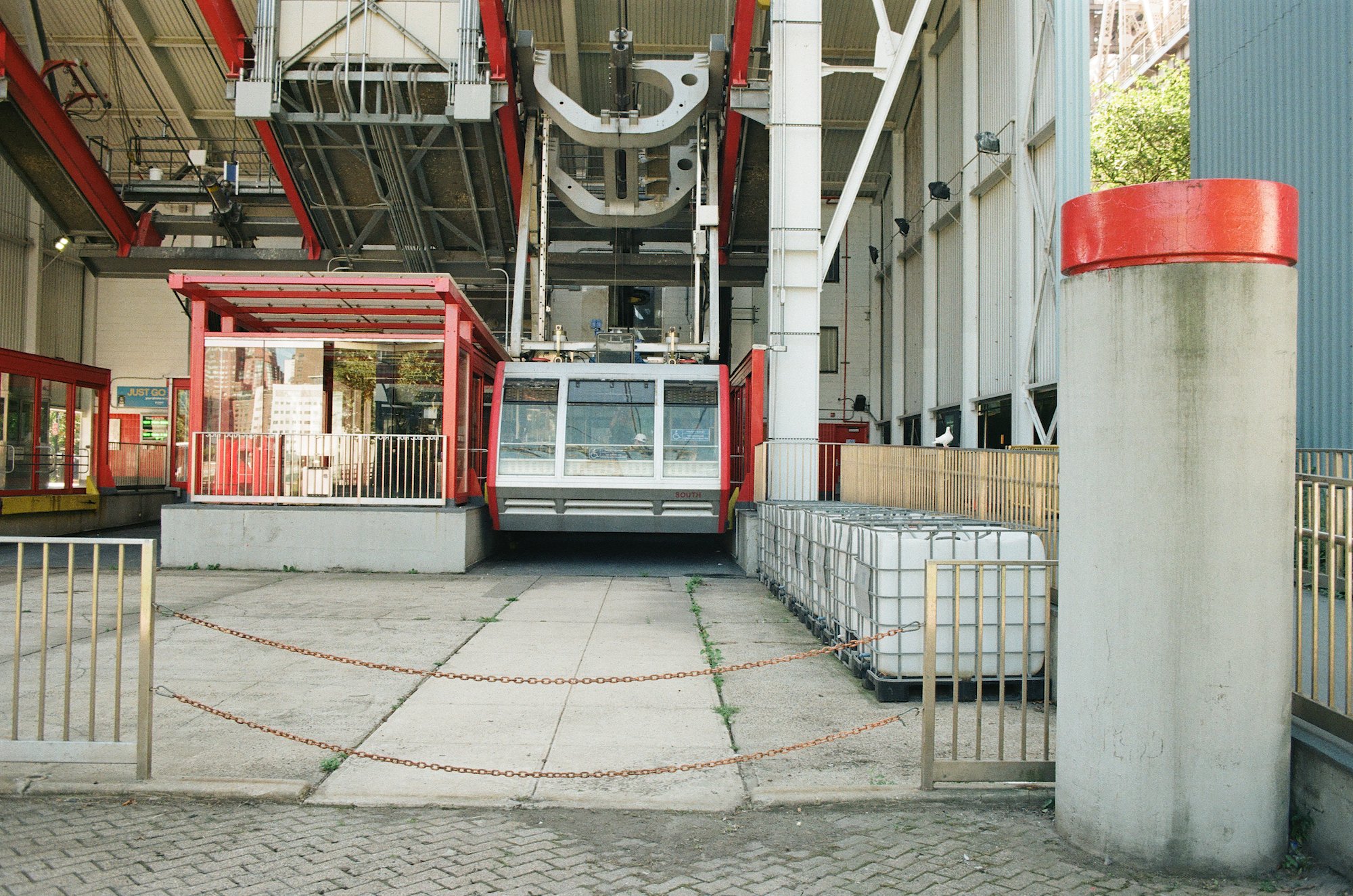 Red and white Roosevelt Island Tram machinery at the station