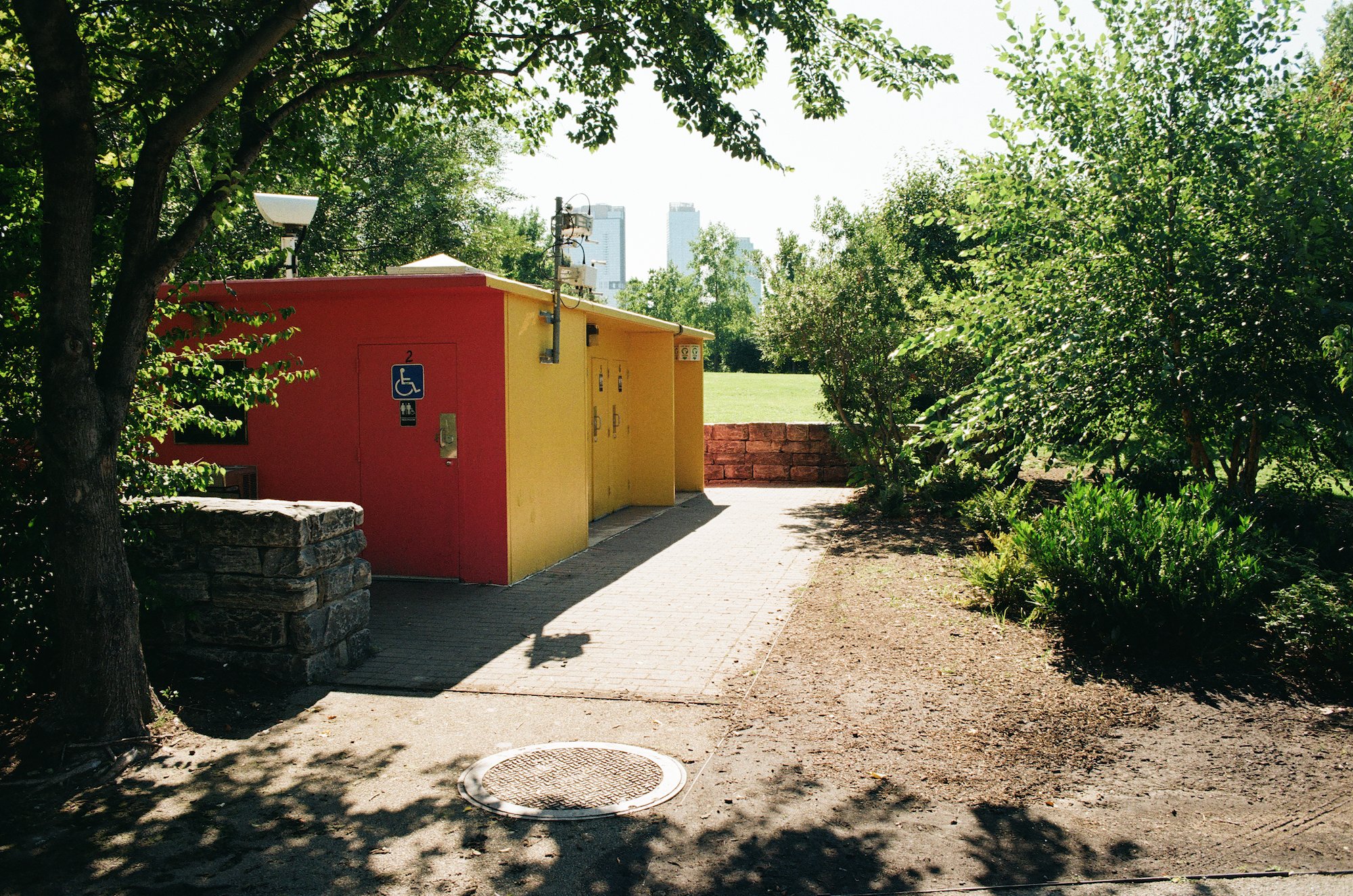 Small red and yellow building surrounded by trees