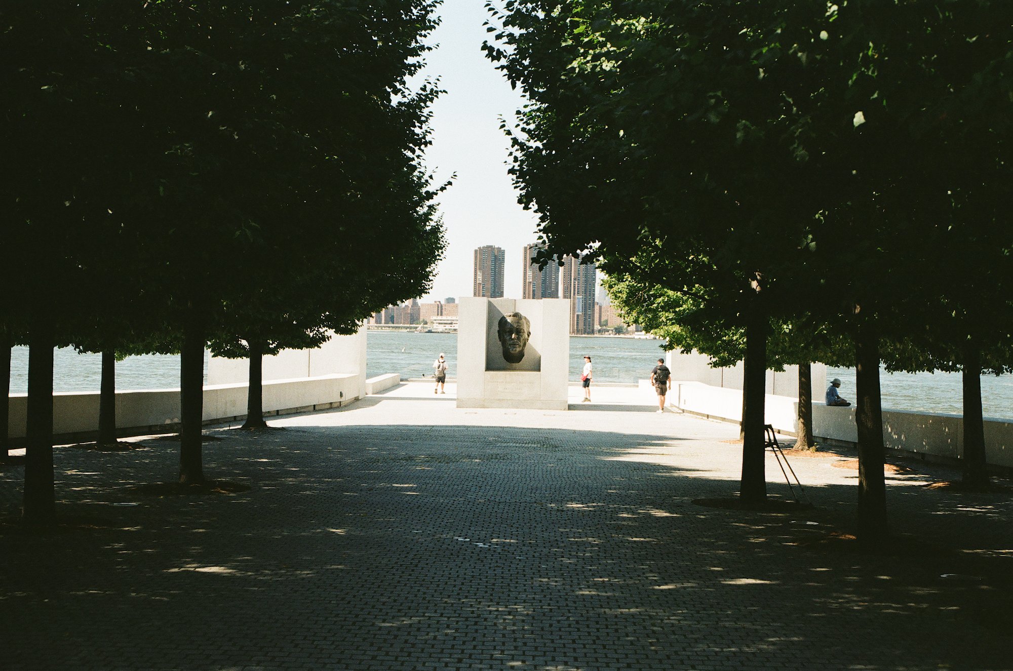 Franklin D. Roosevelt memorial framed by trees, visitors, and the river