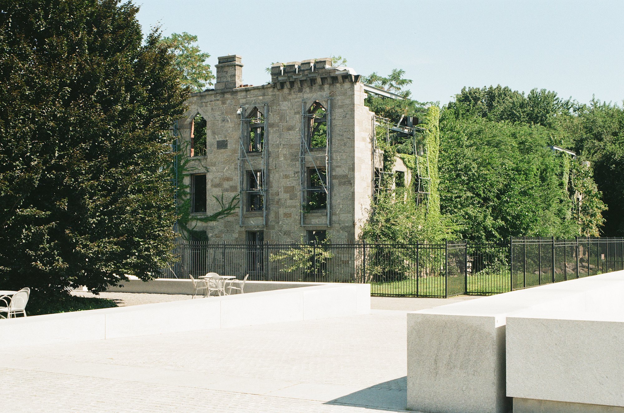 Ivy-covered stone ruins behind the white memorial plaza
