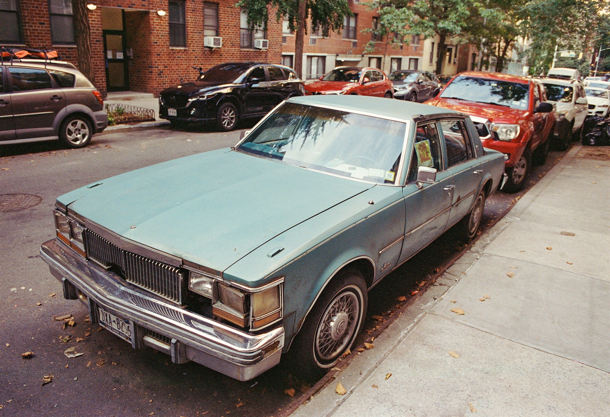 Faded blue vintage car parked on a residential street